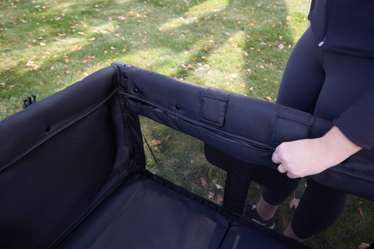 Mom is zipping Carriage's Mesh Sides with Optimal Ventilation's Design