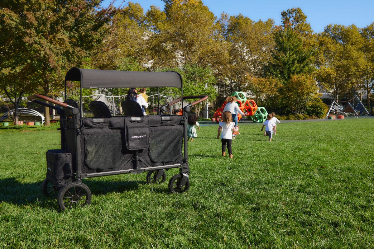 W6 Luxe Pro Stroller Wagon is parked on a grass terrain